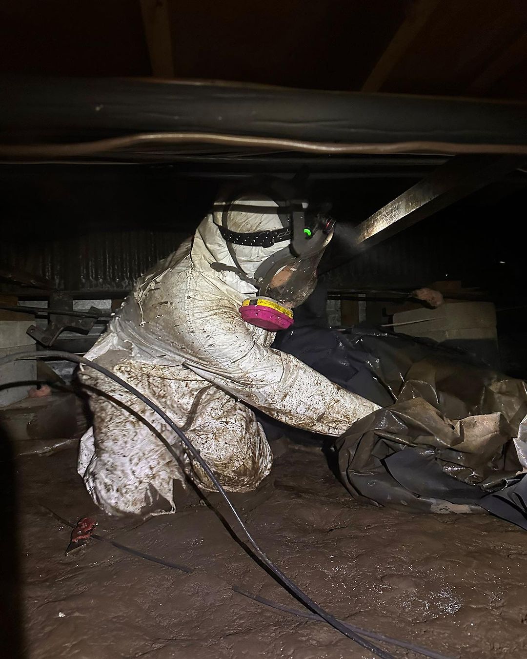 Attic Crawl team member getting dirty cleaning up crawl space